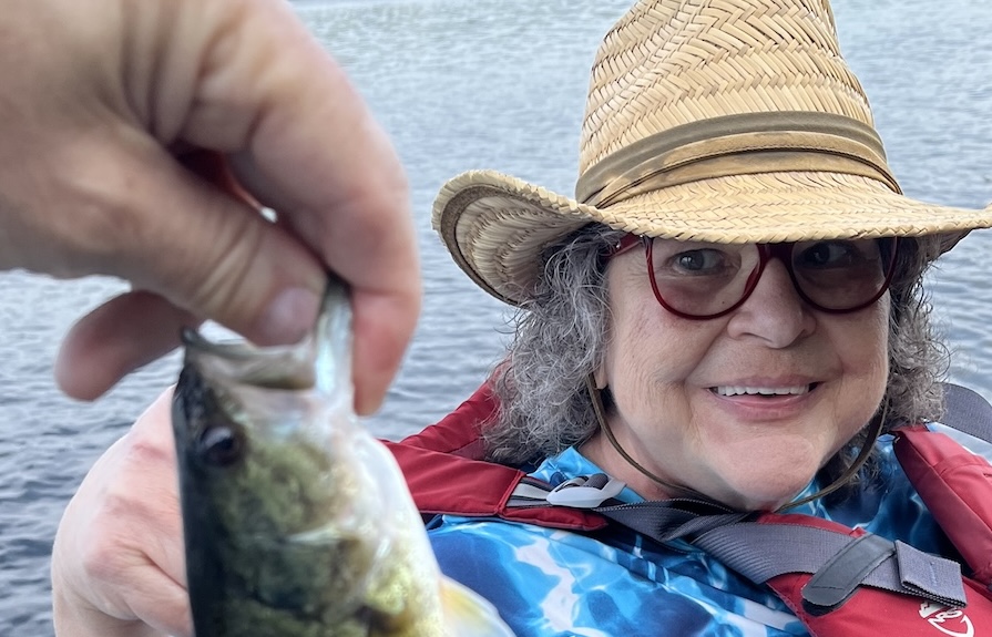 Marcia on the lake, the fish she caught in the foreground